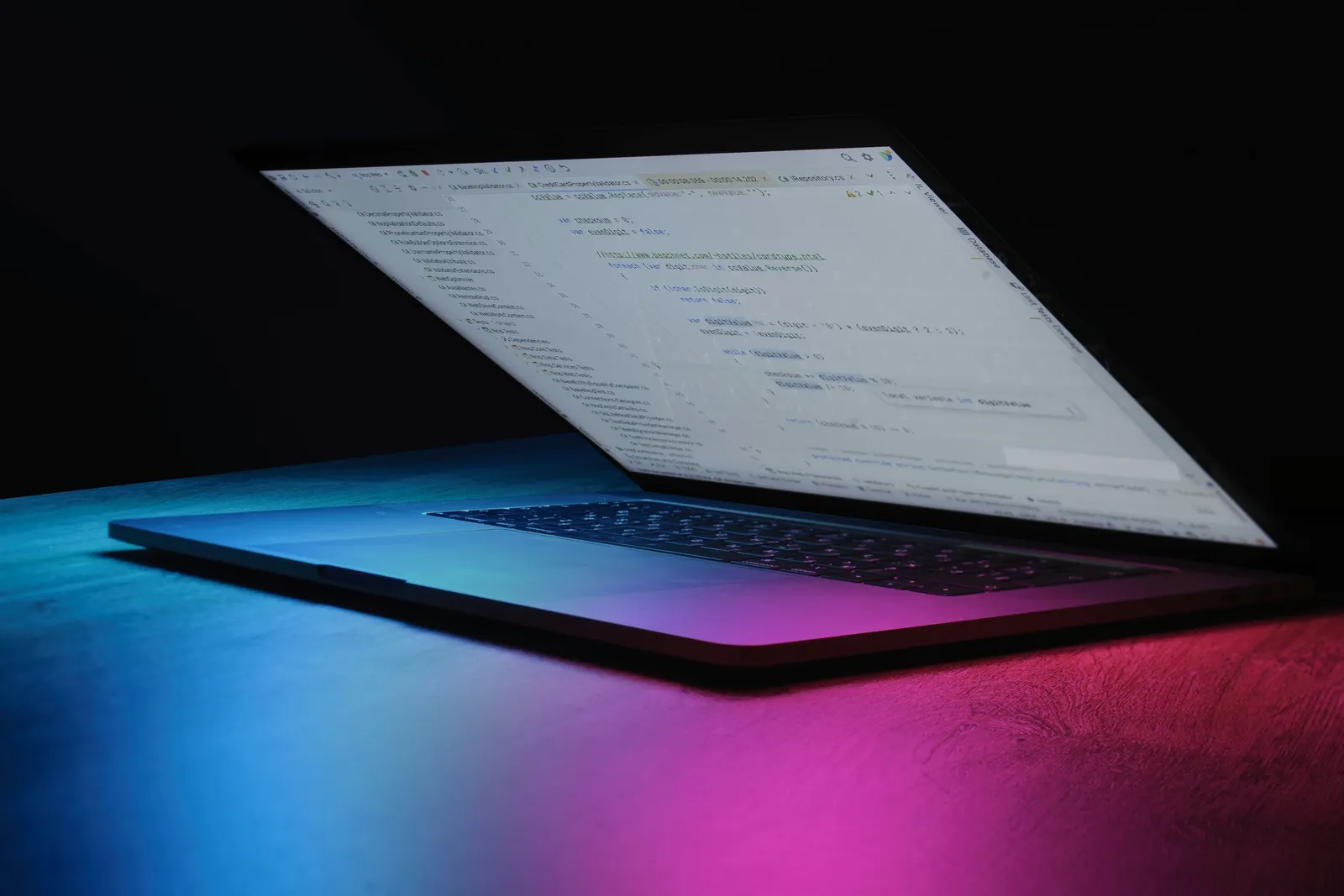 Portatile aperto su una scrivania, illuminato da luci al neon